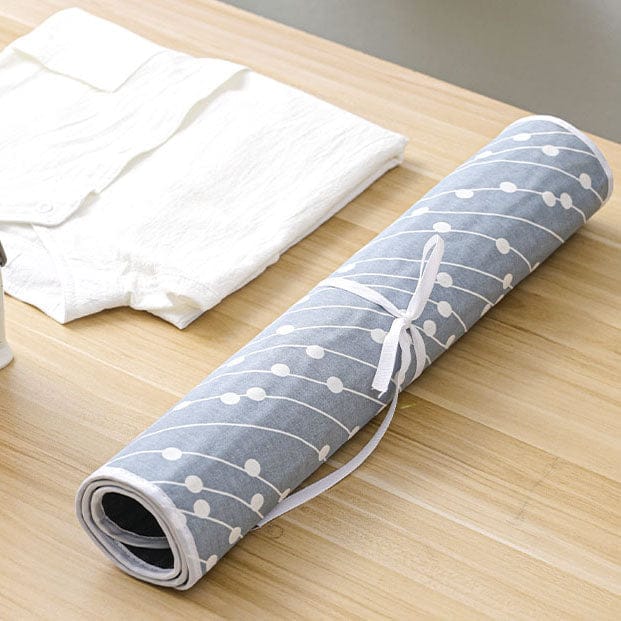 Blaue, zusammengrollte Bügelmatte mit weissem Muster