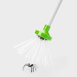 Grüner Insektenfänger mit weissen Borsten und weisser Stange in einem Anwendungsbeispiel mit einer künstlichen Spinne