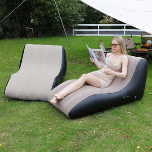 Zwei beige-schwarze, aufblasbare Liegesofas in einem Anwendungsbeispiel mit einer Frau im Garten