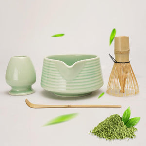 Matcha-Set mit Schale, Bambusbesen, Löffel und grünem Pulver auf hellem Hintergrund