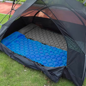 Blaue und graue Camping-Matratze in einem Zelt nebeneinander gelegt