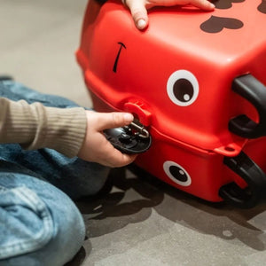 Roter, draufsitzbarer Kinderkoffer in einem Öffnungsbeispiel