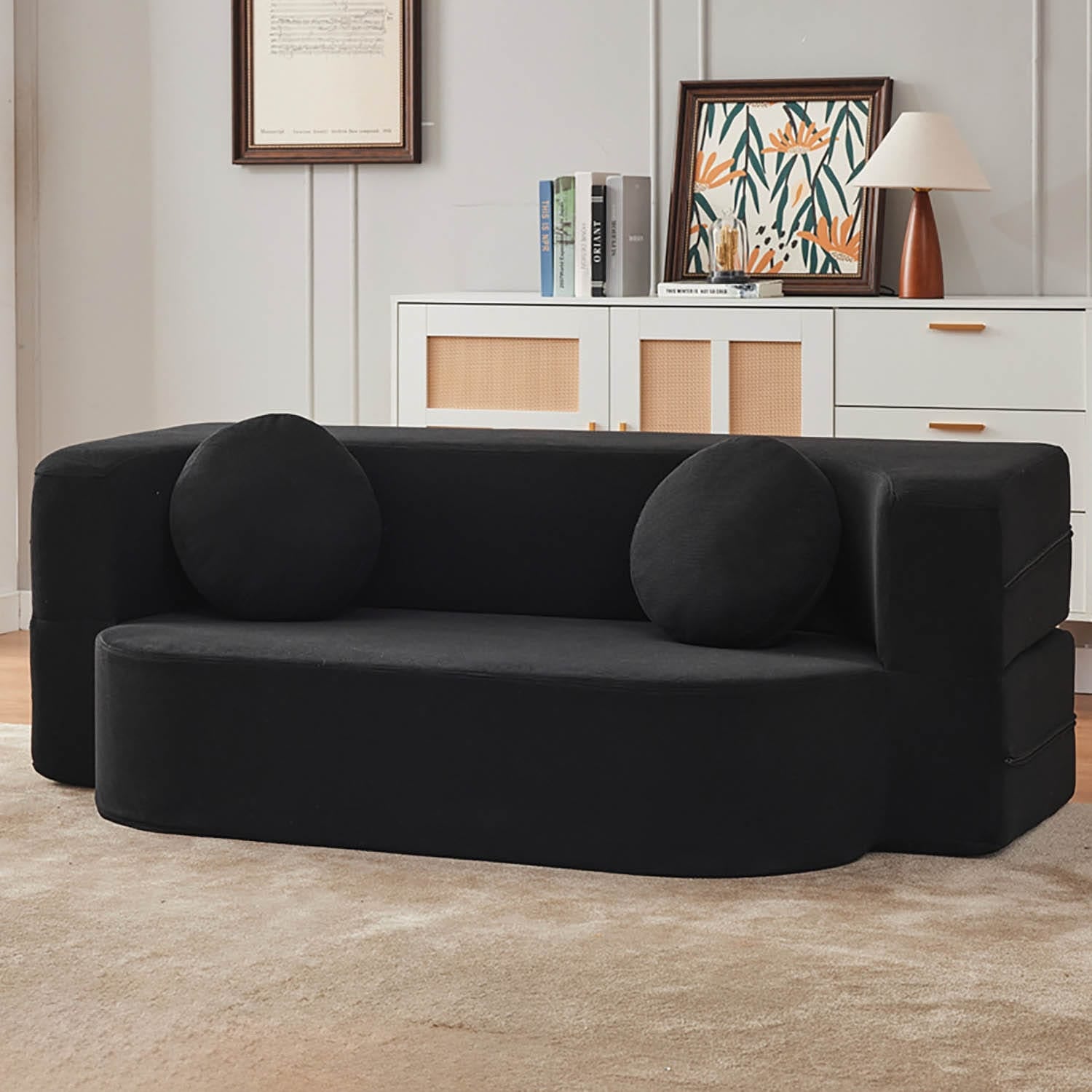 Schwarzes AirBloom Sofa mit zwei runden Kissen in einem Aufstellbeispiel