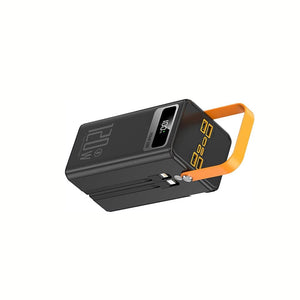 Schwarze Powerbank mit zwei Kabeln, einer digitalen Akkuanzeige, einem gelben Griff und verschiedenen Anschlüssen