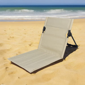 Verstellbare, beige Strandmatte mit schwarzer Stütze in einem Beispiel am Strand