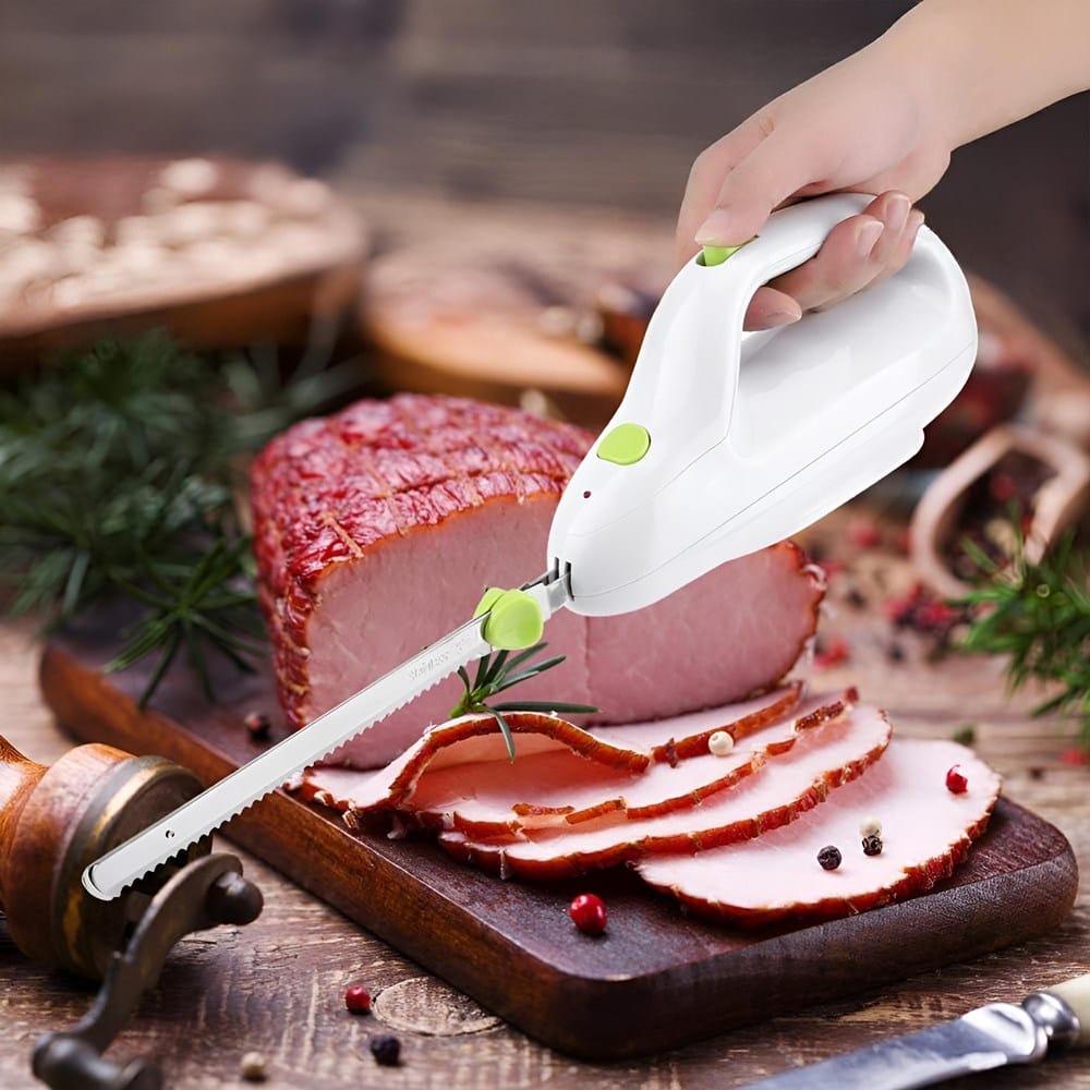 Weises, handgehaltenes Elektromesser mit silberner Klinge in einem Anwendungsbeispiel mit Fleisch