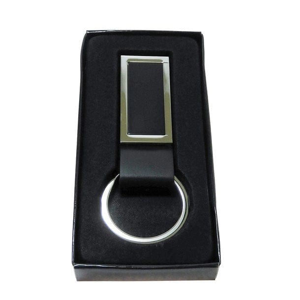 Schwarzer Schlüsselanhänger aus Leder mit silbernem Metallring und rechteckigem Metallrahmen an der Vorderseite in schwarzer Verpackung