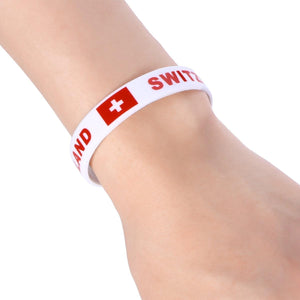 Weisses Silikonarmband mit roter "Switzerland" Aufschrift und schweizer Flagge an einem Arm