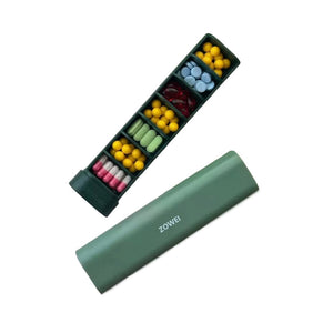 Grüne, ausfahrbare sieben Tage Tablettenbox mit verschiedenen Tabletten darin