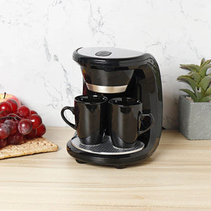Schwarze Minikaffeemaschine mit zwei Tassen und in einem Anwendungsbeipsiel