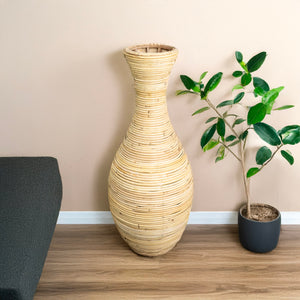 Detaillierte, beige Bodenvase, unten breit und oben dünn in einem zweiten Anwendungsbeispiel mit beiger Wand im Hintergrund