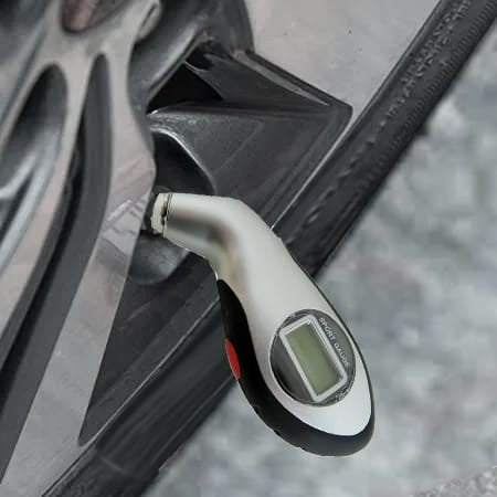 Silberner, digitaler Reifendruckmesser in einem Anwendungsbeispiel