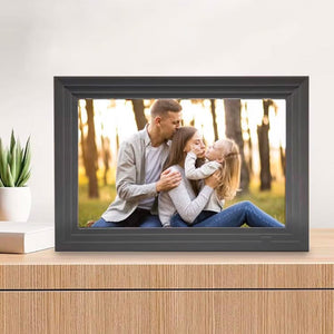 Schwarzer digitaler Bilderrahmen auf hölzernem Regal mit anderem Fotobeispiel