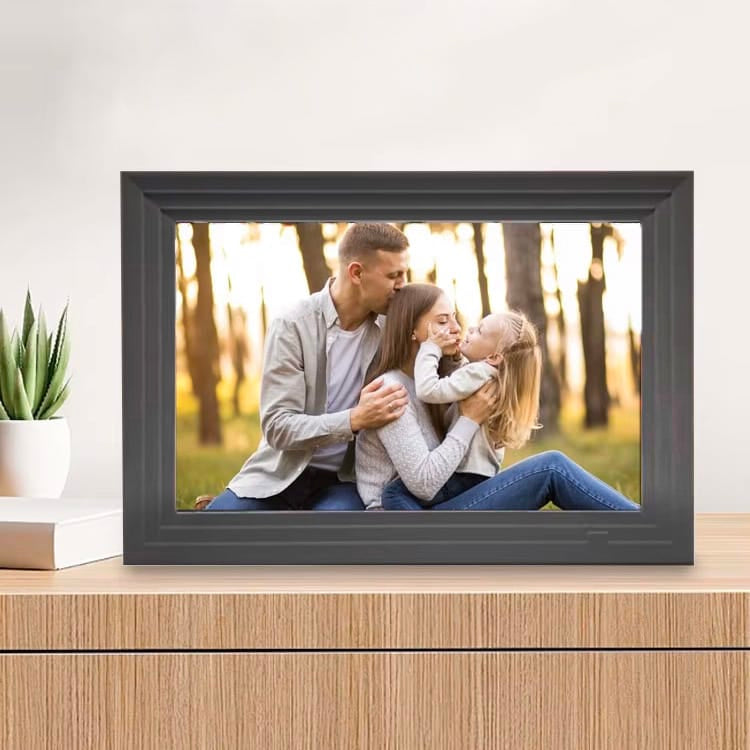 Schwarzer digitaler Bilderrahmen auf hölzernem Regal mit anderem Fotobeispiel