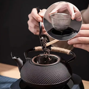 Schwarze Teekanne in asiatischem Stil in einem Anwendungsbeispiel wie Tee in die Kanne gemischt wird