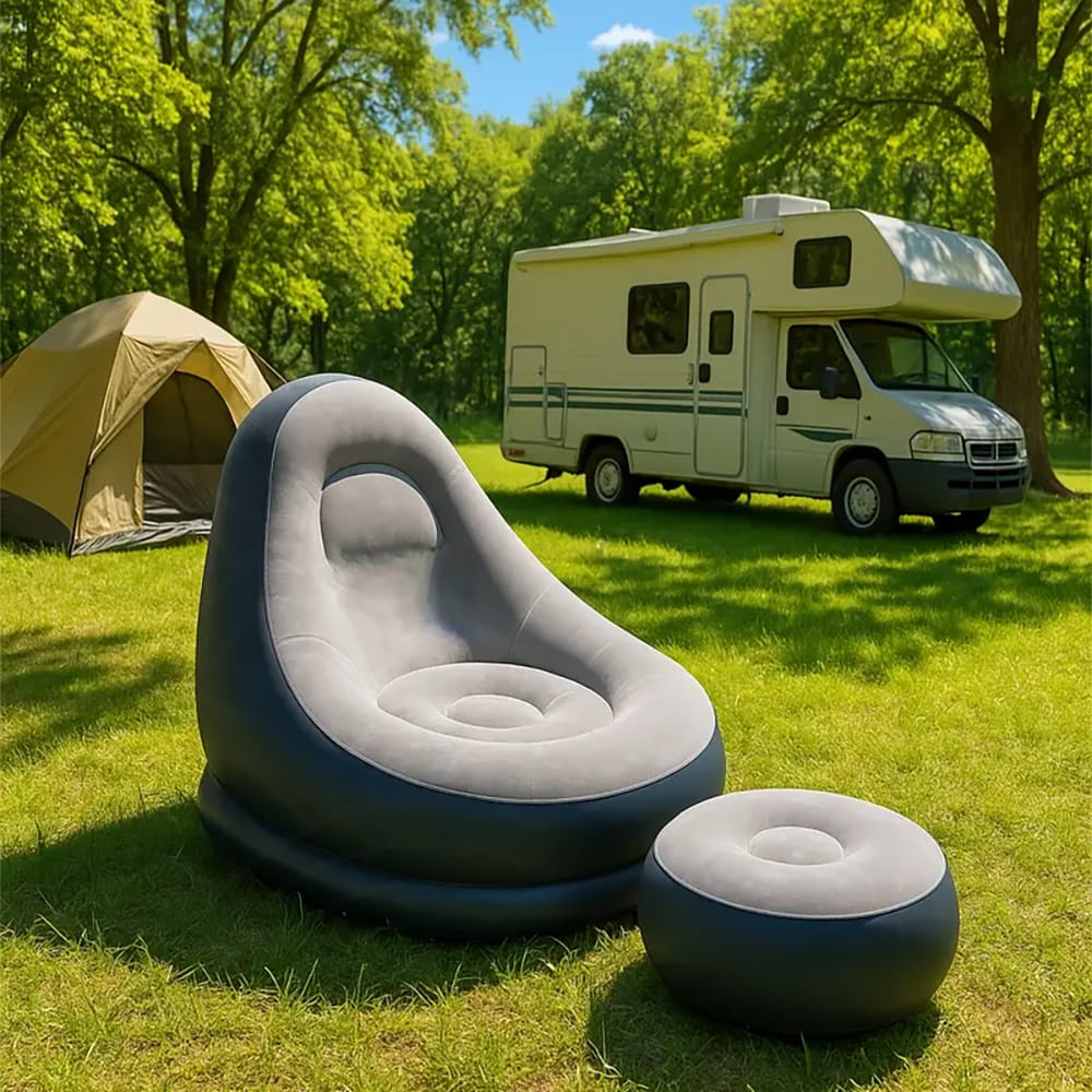 Aufgeblasener, grau-schwarzer Sessel mit kleinem aufgeblasenem Fusshocker in einem Aufstellbeispiel auf einem Campingplatz