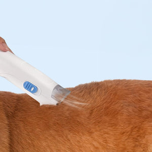 Weisse Hundeschermaschine mit weissem Tierhaar-Staubsauger in einem Anwendungsbeispiel mit einem Hund