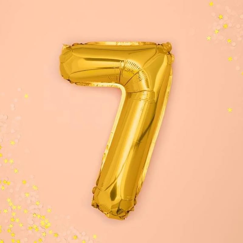 Goldener "7" Ballon auf rosa Hintergrund
