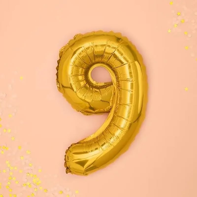 Goldener "9" Ballon auf rosa Hintergrund