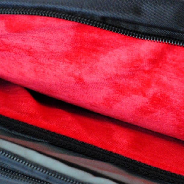 Schwarze Laptoptasche mit geöffnetem kleinen Fach mit rotem Innenstoff