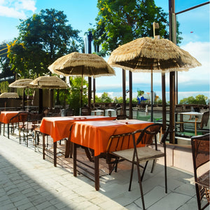 Beiger Sonnenschirm mit Holz Ständer im Hawaii Stil in einem Anwendungsbeispiel in einem Restaurant